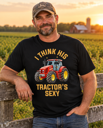 Farmer wearing the funny tractor graphic tee by a farm fence