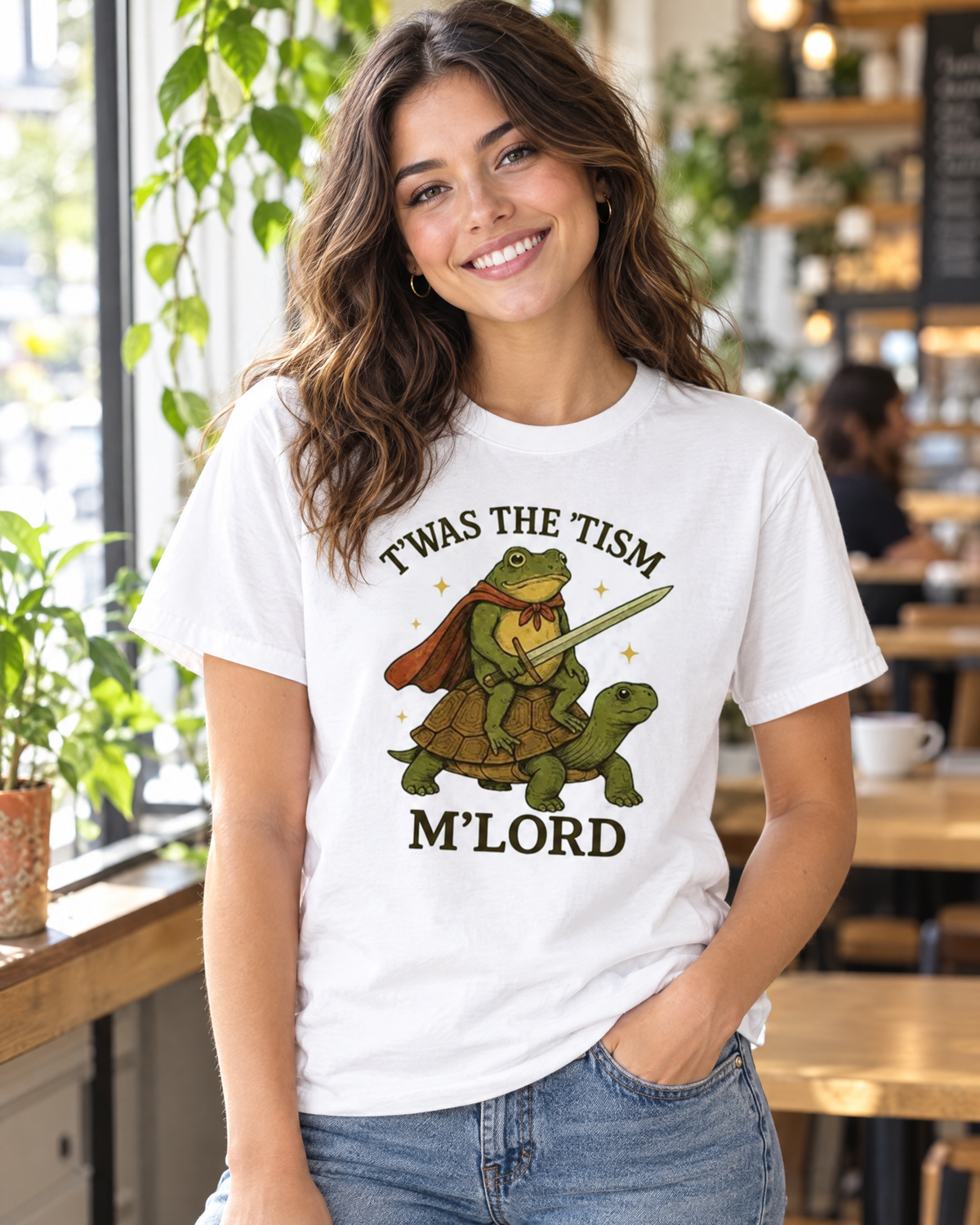 Woman wearing the Twas The Tism M'Lord funny frog graphic tee in a cafe